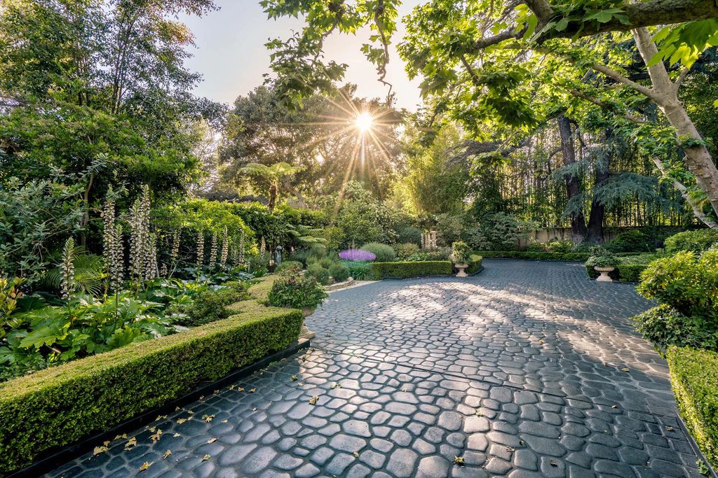 The Beverly Hills Estate, an exceptionally private Tudor-style residence surrounded by magnificent gardens, detailed with French country flair boasting classic design, majestic proportions, bucolic setting and unrivaled amenities is now available for sale. This home located at 1005 Woodland Dr, Beverly Hills, California