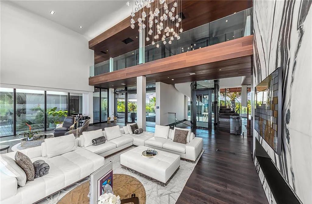 1005 NE Doubloon Drive, Stuart, Florida is one of the most iconic homes on the Treasure Coast marries contemporary design with utter livability, featured amenities include 2 separate garages, fitness center, theatre, game room, lounge, outdoor shower, basketball, and waterscapes.