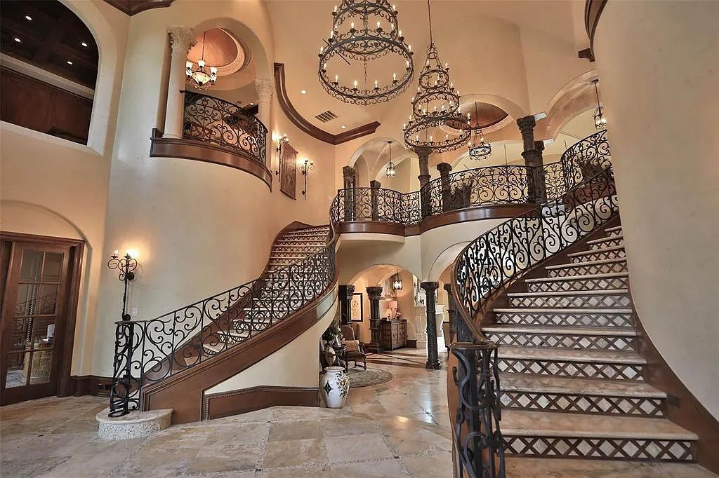 38262 Windy Ridge Trail, Magnolia, Texas is a sprawling home set on 20+ac resort-like grounds with features includes twin wrought-iron staircases, custom chandeliers, 2-story library, games room plus pub and more.