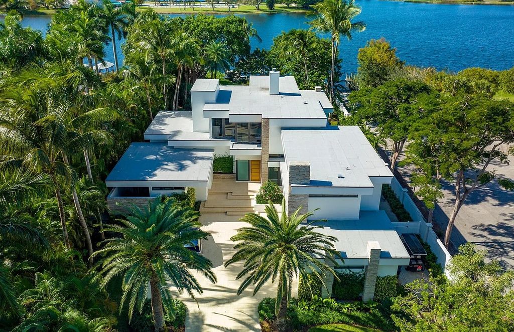 1080 Lake Drive, Delray Beach, Florida is a Frank Lloyd Wright-inspired estate perfect for water-sports enthusiasts are a boat house and dock, and inviting indoor outdoor entertaining, two loggias overlook the pool. 