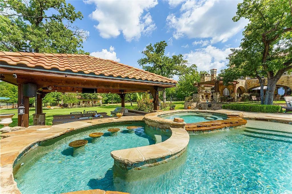 127 River Oak Court, Weatherford, Texas is a one of a kind estate for the luxurious recreational and residential experience with features including large pool with infinity edge, water fall, slide, swim up bar, and extensive decorative lighting.