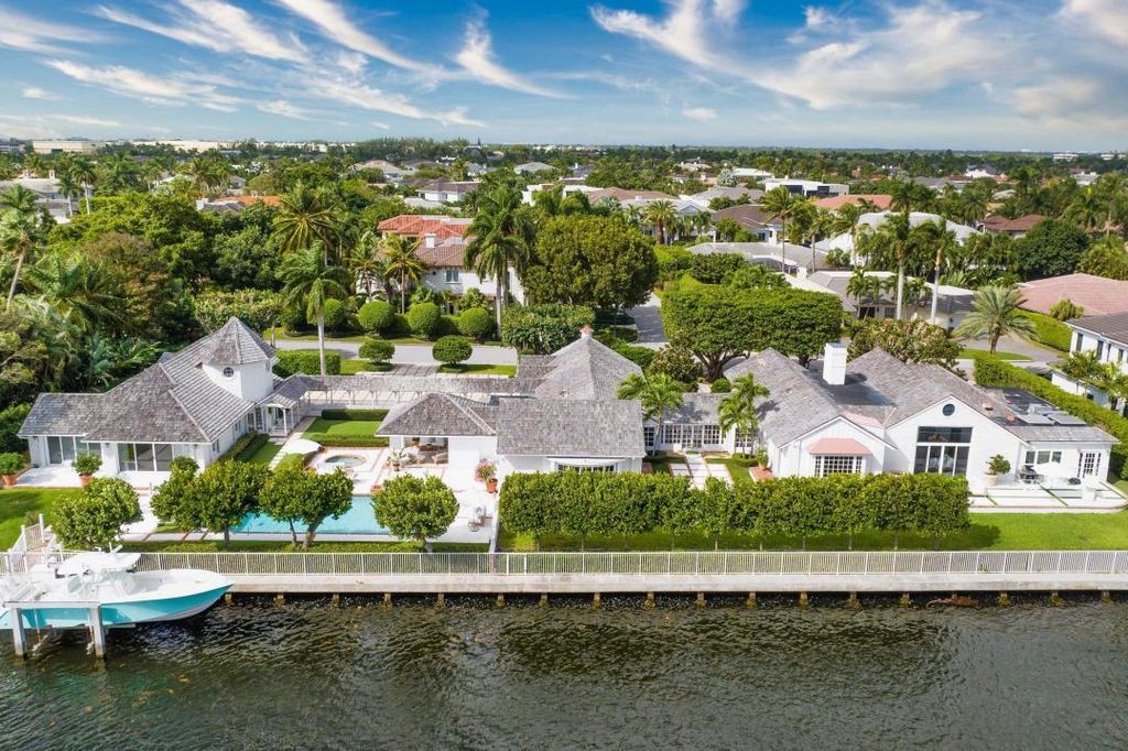 2408 E Maya Palm Drive, Boca Raton, Florida is a sprawling Hampton's Farmhouse-inspired home on Royal Palm Yacht & Country Club's prestigious Intracoastal and sited on 2.5 lots with 261+/- feet of rare waterfrontage. This Home in Boca Raton offers 6 bedrooms and 9 bathrooms with over 5,500 square feet of living spaces.