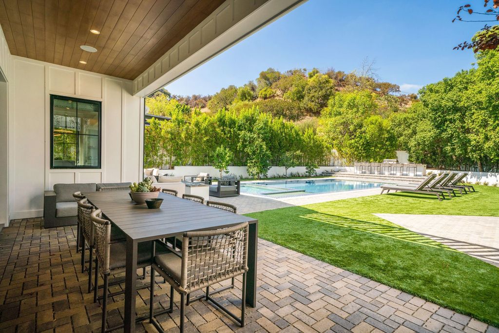 17173 Strawberry Drive, Encino, California is a gated chic farmhouse on a quiet cul de sac in the Encino Hills with the finest custom finishes and designer fixtures throughout the public rooms as well as a sprawling resort-like private backyard.