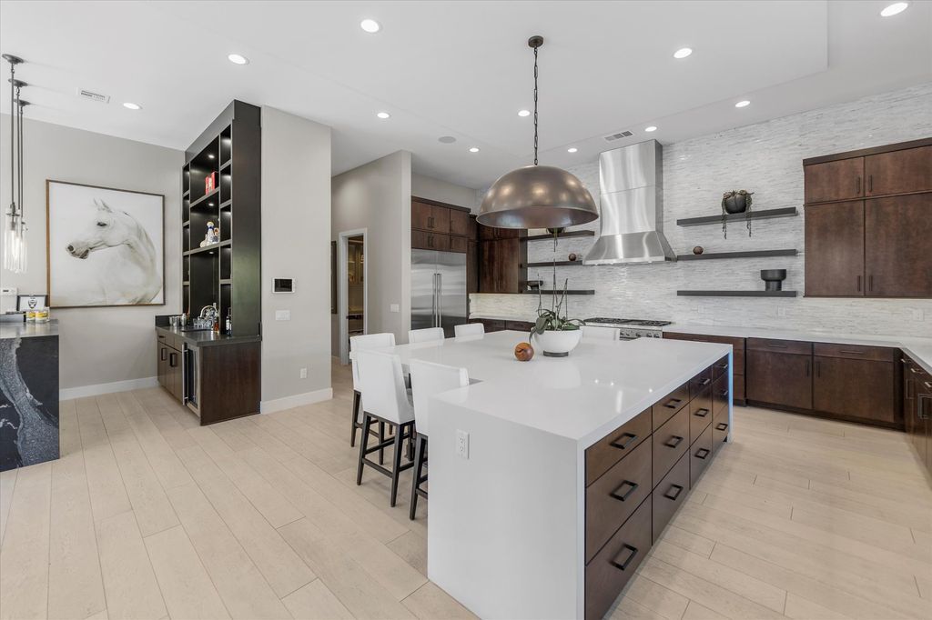 11448 Opal Springs Way, Las Vegas, Nevada is a guard-gated designer dream home with updated amenities including French oak hardwood flooring, silver travertine decking, closets, light fixtures, Control4 home automation, whole-home sound, and more.