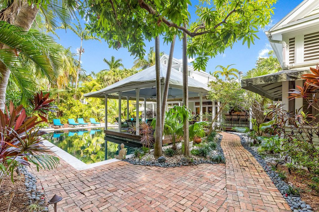 101 Admirals Lane, Key West, Florida,  provides privacy and a lush atmosphere for this remarkable home on a huge 14,000 SF lot, surrounded by a wall of tropical foliage. It is a spectacular property on one of the largest lots in the gated community of Truman Annex, featuring three separate dwellings blending traditional and contemporary architecture.