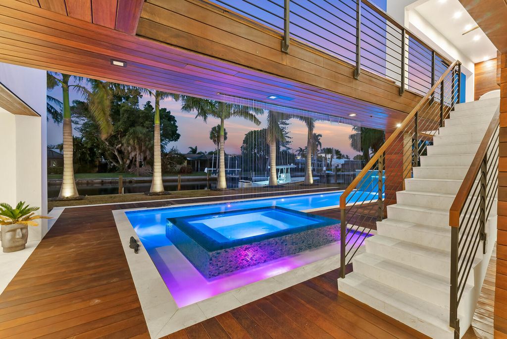 545 Kingfisher Lane, Longboat Key, Florida is a custom built modern canal front Longboat Key home with dramatic wide shell stone stair entrance, massive 60-inch ceramic tile flooring, 20-foot ceilings, skylights, lap-pool with 2 waterfall features, outdoor kitchen adjacent to indoor kitchen, and 5-car garage.