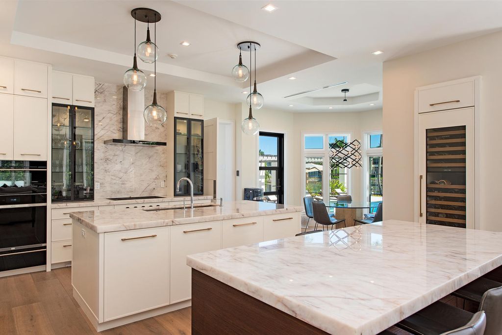 3595 Gin Lane, Naples, Florida is a gated property situated on nearly an acre overlooking Hidden Bay with quick access to the Gulf of Mexico, beautifully renovated and reimagined in 2018 with amenities as a private elevator, cherry wood library, double island in kitchen. 