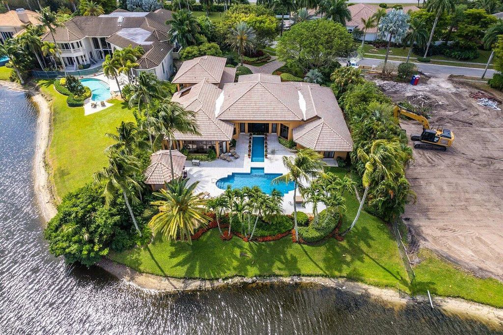 17903 Lake Estates Drive, Boca Raton, Florida, is a beautiful home overlooking the water and golf course on 0.69 acres. A long stone paver driveway surrounds this estate, which is surrounded by beautiful trees and landscaping.