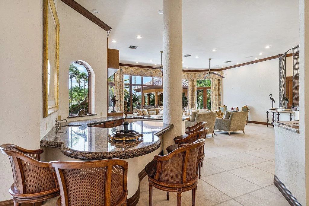 17903 Lake Estates Drive, Boca Raton, Florida, is a beautiful home overlooking the water and golf course on 0.69 acres. A long stone paver driveway surrounds this estate, which is surrounded by beautiful trees and landscaping.