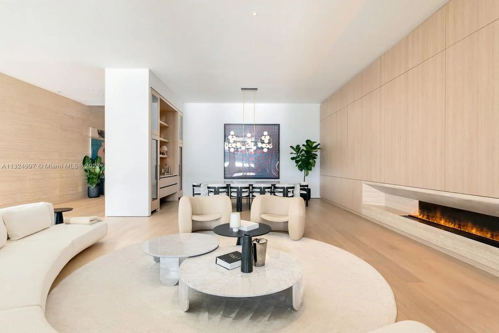 28 W Di Lido Drive, Miami Beach, Florida is stunning home where relaxed island living meets worldly sophistication, incredible features include 12ft ceilings, column-free living, 54ft of automated glass, media bookshelf, wine bar, & vapor fireplace highlight the textured travertine and white oak palette.
