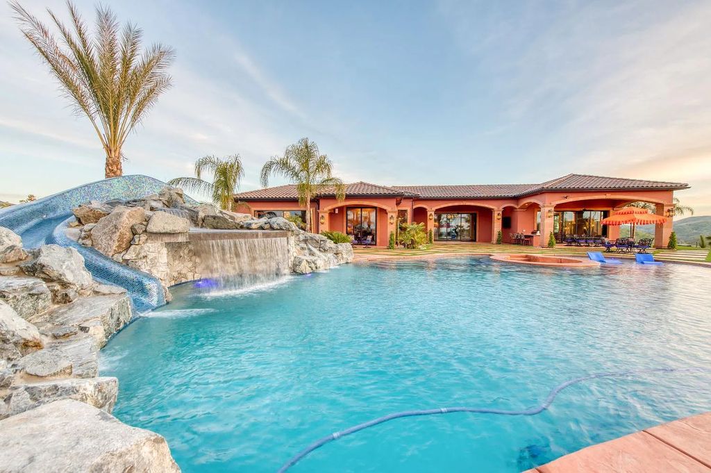 22137 Oak Glen Lane, Friant, California is a newly constructed home boasts 360 degree views of the snow-capped Sierras, Millerton Lake, Eagle Springs Golf Course and the City, enjoying the massive resort-style pool which includes a waterslide, private grotto and recessed fire pit.