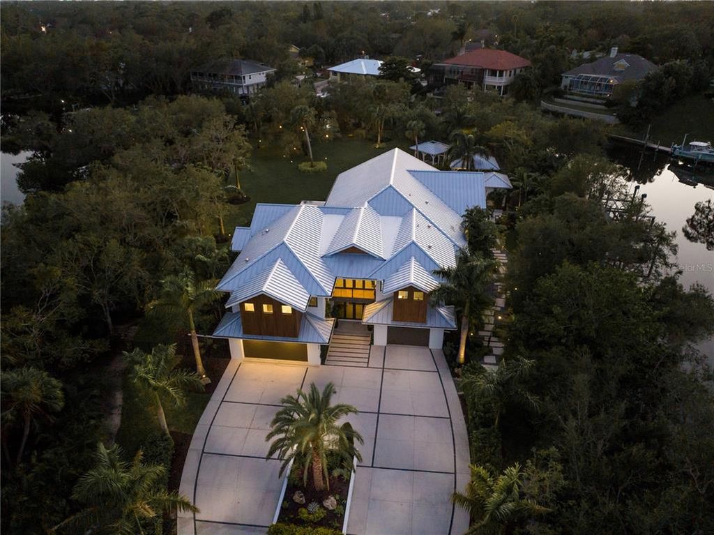 3940 Elysian Woods Lane, Sarasota, Florida is a mature landscaped estate is nestled on 1.47 acres and completely private in a small, gated community with only eight homes, was built with meticulous craftsmanship and bespoke finishes throughout.