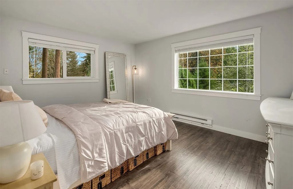 The Home in Woodinville features soaring sun-drenched living spaces with rich hardwood floors and walls of windows, now available for sale. This home located at 16706 NE 179th Street, Woodinville, Washington