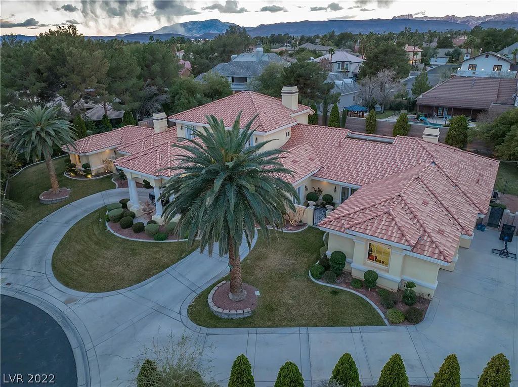 7600 Silver Meadow Court, Las Vegas, Nevada is a resort style estate in an exclusive gated enclave with a generous circular drive, a spacious living room punctuated by a stunning wrought iron floating staircase, a gourmet kitchen, venetian gardens, resort guest house and more.