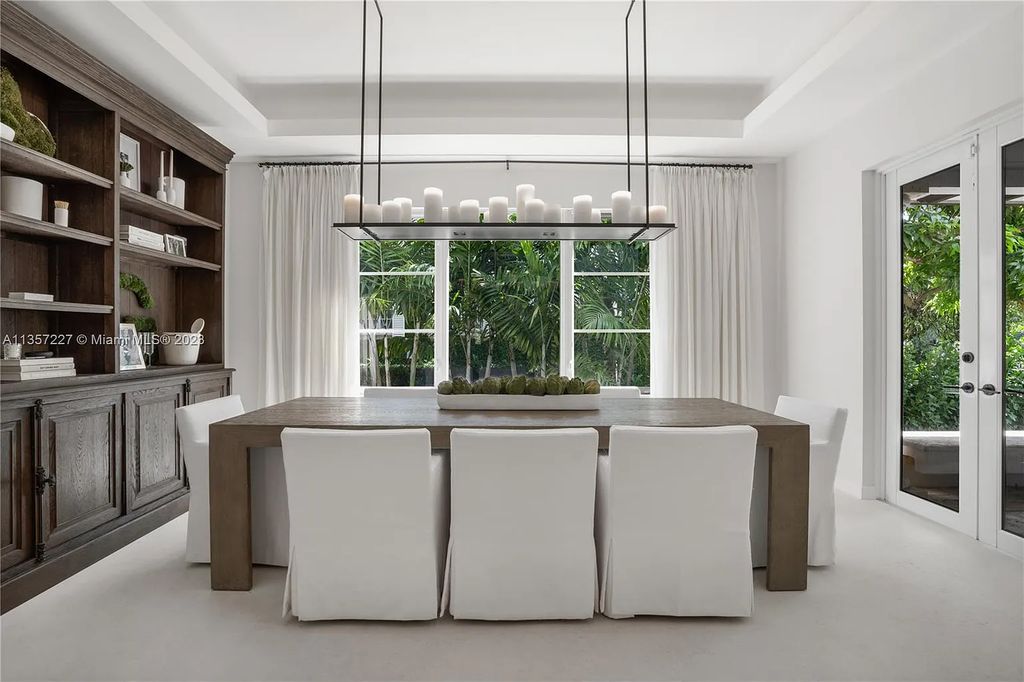 This stunning waterfront home is located at 152 Paloma Drive in the exclusive gated community of Islands of Cocoplum in Coral Gables, Florida. It features 6 bedrooms, 5.5 bathrooms, a brand new kitchen with top-of-the-line appliances, impact windows throughout, and a fabulous custom bar.