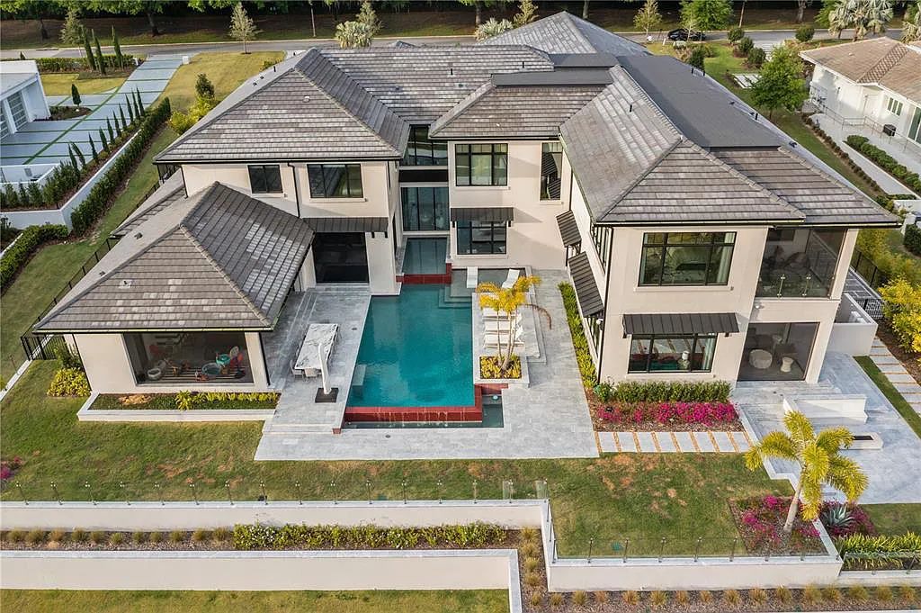 This luxurious lakefront mansion at 9306 Blanche Cove Drive in Windermere, Florida, is a custom-crafted masterpiece built for the ultimate sports enthusiast. The 5-bedroom, 8-bath home spans 14,856 square feet and includes a 6,060 square foot air-conditioned full-sized basketball court, a theater, an exercise room with sauna, and a two-story master closet.