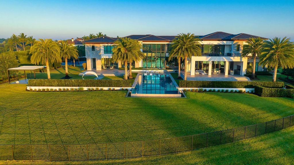 This 7-bedroom, 12-bathroom lakefront estate is a private oasis situated on a 2.6-acre point lot with 600 feet of waterfront in Delray Beach, Florida. 9480 Bent Grass Court features glass walls that connect the lake side of the home to expansive terraces, a lanai with a summer kitchen, and an infinity pool with a sun shelf.