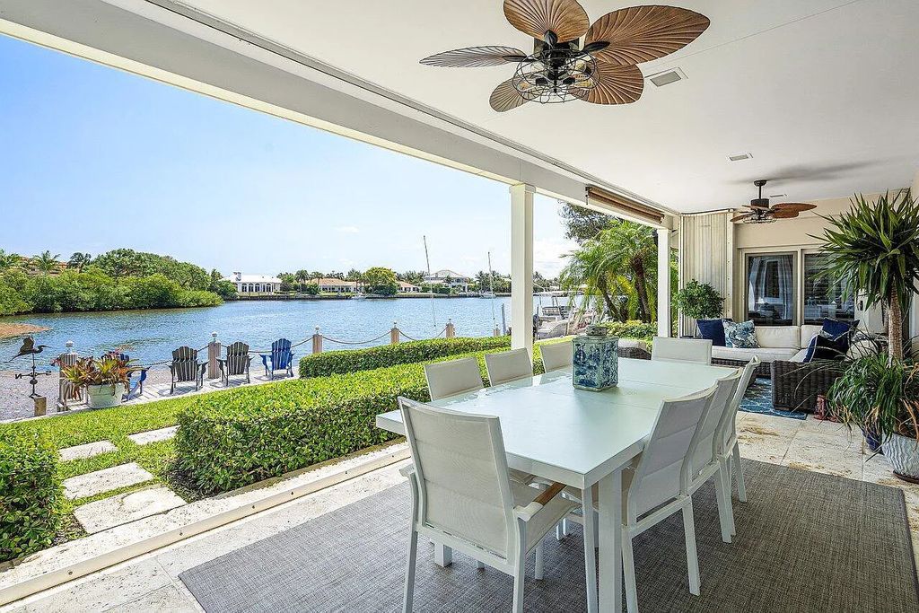 This luxurious 4-bed, 6-bath island estate at 1400 Lands End Road in Manalapan, Florida offers direct water access, a private boat dock with lift, and a large pool area with covered loggia. 