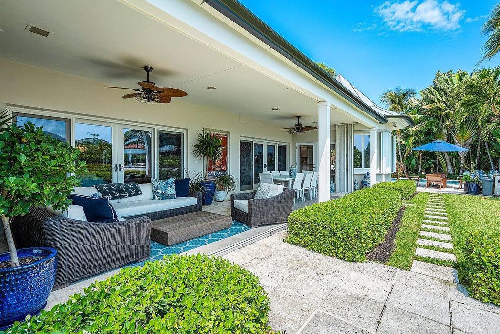 This luxurious 4-bed, 6-bath island estate at 1400 Lands End Road in Manalapan, Florida offers direct water access, a private boat dock with lift, and a large pool area with covered loggia. 