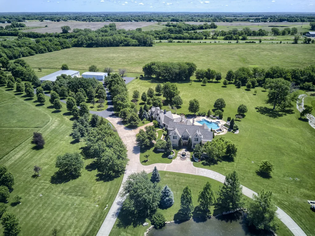 20485 Antioch Road Home in Bucyrus, Kansas. Discover this stunning 29-acre estate that offers breathtaking views and a relaxed country setting. Built by the renowned architect Lyle Holthaus, this estate exudes luxury and attention to detail at every turn. Nestled in a picturesque countryside, the custom-built home welcomes you with a private gate, a serene pond, beautiful stonework, a captivating water feature, and a fabulous entryway.