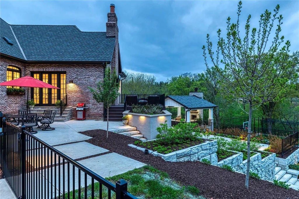 23 Brookwood Road Home in Saint Louis, Missouri. This remarkable residence showcases a grand two-story foyer, a library-paneled study, an elegant dining room, and a stunning great room with Palladian windows and a wet bar. The designer kitchen boasts quartzite countertops and commercial-grade appliances, while the master bedroom suite offers a marble bath and a private deck. 