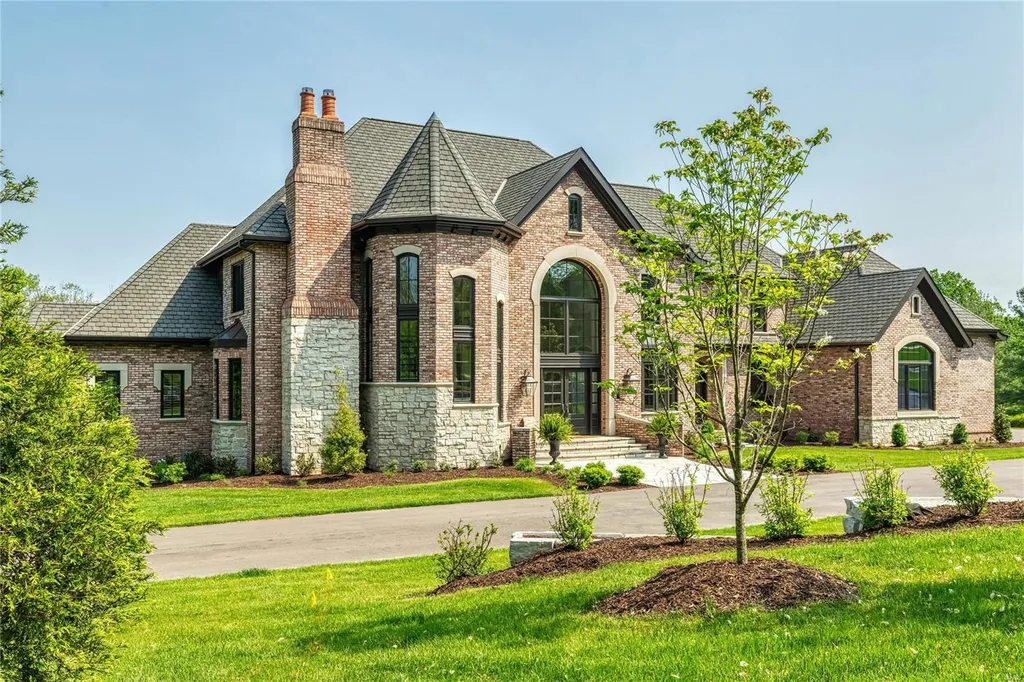 23 Brookwood Road Home in Saint Louis, Missouri. This remarkable residence showcases a grand two-story foyer, a library-paneled study, an elegant dining room, and a stunning great room with Palladian windows and a wet bar. The designer kitchen boasts quartzite countertops and commercial-grade appliances, while the master bedroom suite offers a marble bath and a private deck. 