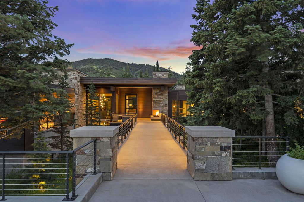 2470 W White Pine Lane Home in Park City, Utah. Bask in year-round mountain living with unique private ski access at this turnkey modern sanctuary on 5.4 acres of mature evergreens. Enjoy stunning ski-run views and extreme privacy in this luxurious home featuring oak cabinets, Lagos Blue Limestone, concrete, and stone finishes. 