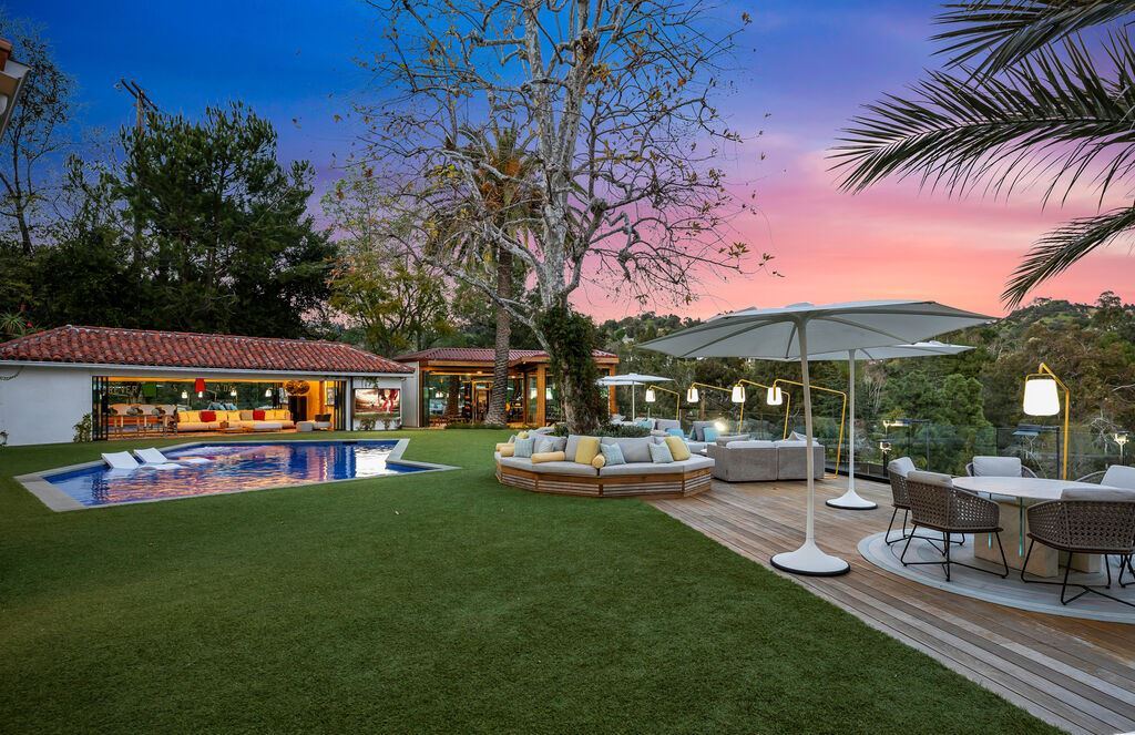 2625 Deep Canyon Drive Home in Beverly Hills, California. Nestled within a serene and secluded setting, this gated estate boasts a private tennis court and breathtaking canyon views, embraced by mature landscaping. Tucked away from the street, a long driveway leads to a gated motor-court, providing ample space for multiple vehicles and a generous four-car garage. M