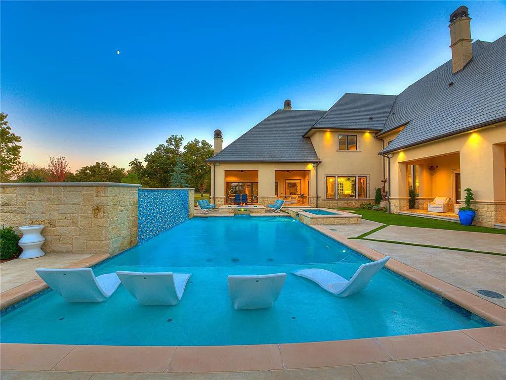 308 Deep Fork Circle, Arcadia, Oklahoma. This ultra-luxury home in Sugar Hill boasts multiple outdoor living spaces, water features, and extensive landscaping, providing privacy and exclusivity. The house features a gourmet kitchen, wine cellar, game room, and THX certified home theater. 