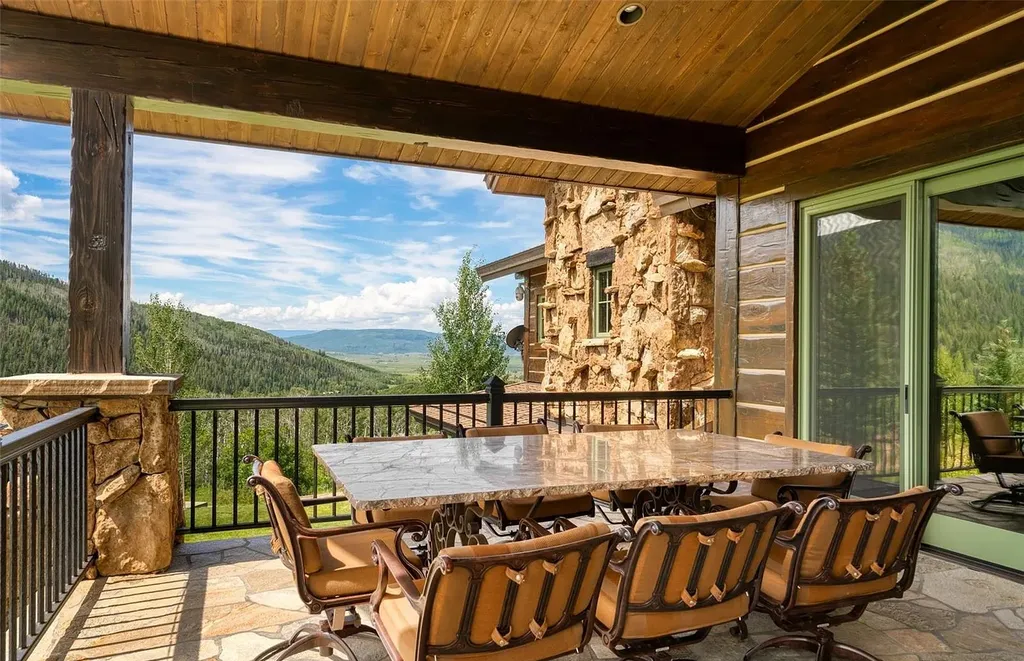 34205 Catamount Drive Home in Steamboat Springs, Colorado. Discover the allure of this exquisite mountain retreat perched atop Catamount Ranch. With stunning panoramic views, this home seamlessly blends into its natural surroundings, offering privacy and tranquility. Immerse yourself in the grandeur of the interior, featuring a towering stone fireplace, exposed wooden beams, and floor-to-ceiling windows that showcase the breathtaking vistas.