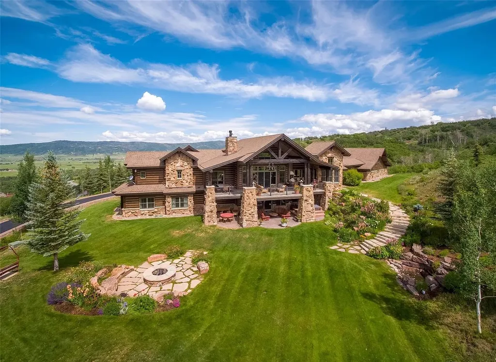 34205 Catamount Drive Home in Steamboat Springs, Colorado. Discover the allure of this exquisite mountain retreat perched atop Catamount Ranch. With stunning panoramic views, this home seamlessly blends into its natural surroundings, offering privacy and tranquility. Immerse yourself in the grandeur of the interior, featuring a towering stone fireplace, exposed wooden beams, and floor-to-ceiling windows that showcase the breathtaking vistas.