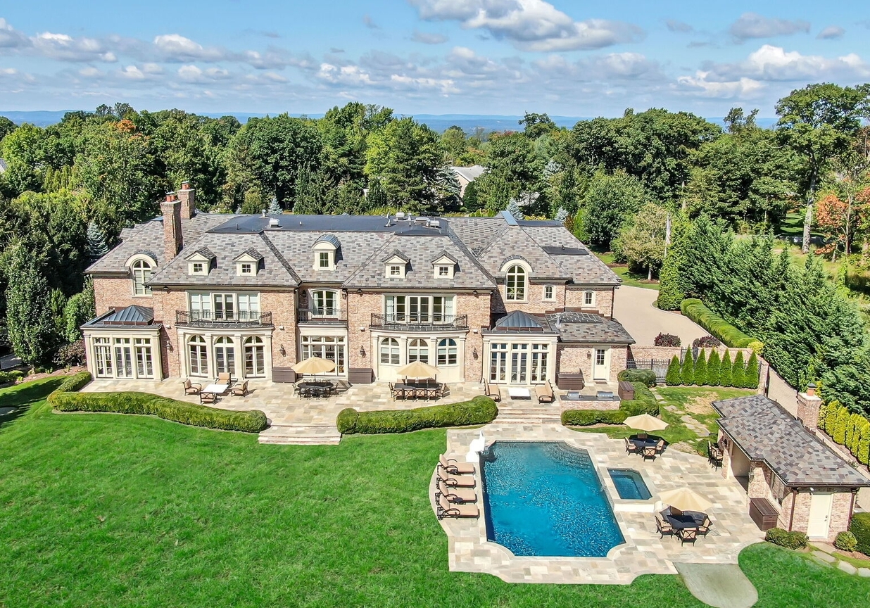 4 Stone Tower Drive Home in Alpine, New Jersey. Discover the epitome of luxury living at the majestic Alpine estate, one of the finest homes in Northern Bergen County. Set on 4 gated manicured acres in Rio Vista, this impeccably designed manor by James Paragono showcases architectural excellence and meticulous craftsmanship. With 22,782 square feet of opulent living space spread across 4 levels, this estate boasts 12' ceilings, luxurious amenities, and breathtaking features, including a pool, cabana, tennis court, guest house, and putting green. The residence offers garage parking for 8 cars, an elevator servicing all floors, 25 rooms, a new Salerno kitchen, 8 bedrooms, 9 full and 3 half baths, bowling alleys, a home theater, a commercial generator, and state-of-the-art high-efficiency furnaces.