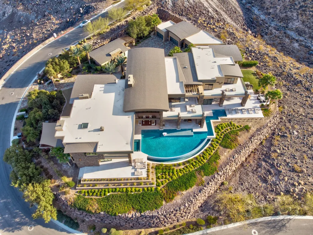 This extraordinary estate located at 761 Dragon Ridge Drive in Henderson, NV offers an unparalleled level of luxury and sophistication. Situated within the exclusive 9-lot enclave in Macdonald Highlands, this magnificent residence is nestled on a sprawling 1.23-acre lot, providing ample space and privacy.