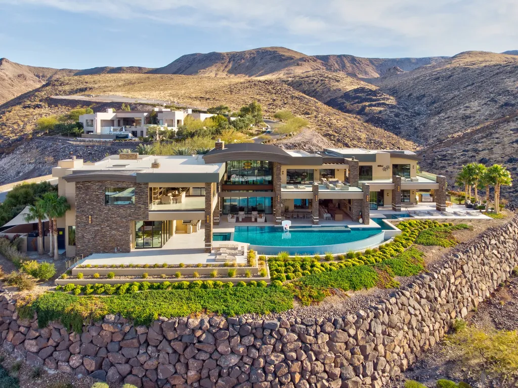 This extraordinary estate located at 761 Dragon Ridge Drive in Henderson, NV offers an unparalleled level of luxury and sophistication. Situated within the exclusive 9-lot enclave in Macdonald Highlands, this magnificent residence is nestled on a sprawling 1.23-acre lot, providing ample space and privacy.