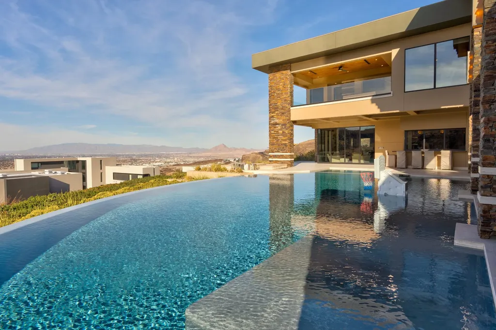 This extraordinary estate located at 761 Dragon Ridge Drive in Henderson, NV offers an unparalleled level of luxury and sophistication. Situated within the exclusive 9-lot enclave in Macdonald Highlands, this magnificent residence is nestled on a sprawling 1.23-acre lot, providing ample space and privacy.