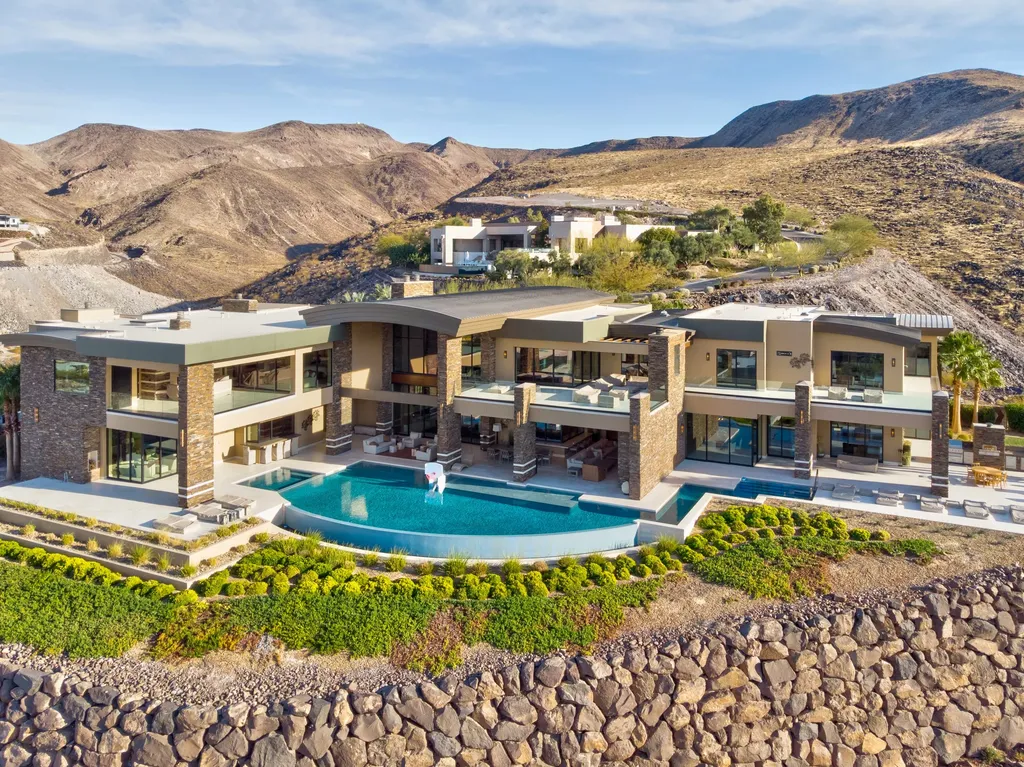 This extraordinary estate located at 761 Dragon Ridge Drive in Henderson, NV offers an unparalleled level of luxury and sophistication. Situated within the exclusive 9-lot enclave in Macdonald Highlands, this magnificent residence is nestled on a sprawling 1.23-acre lot, providing ample space and privacy.