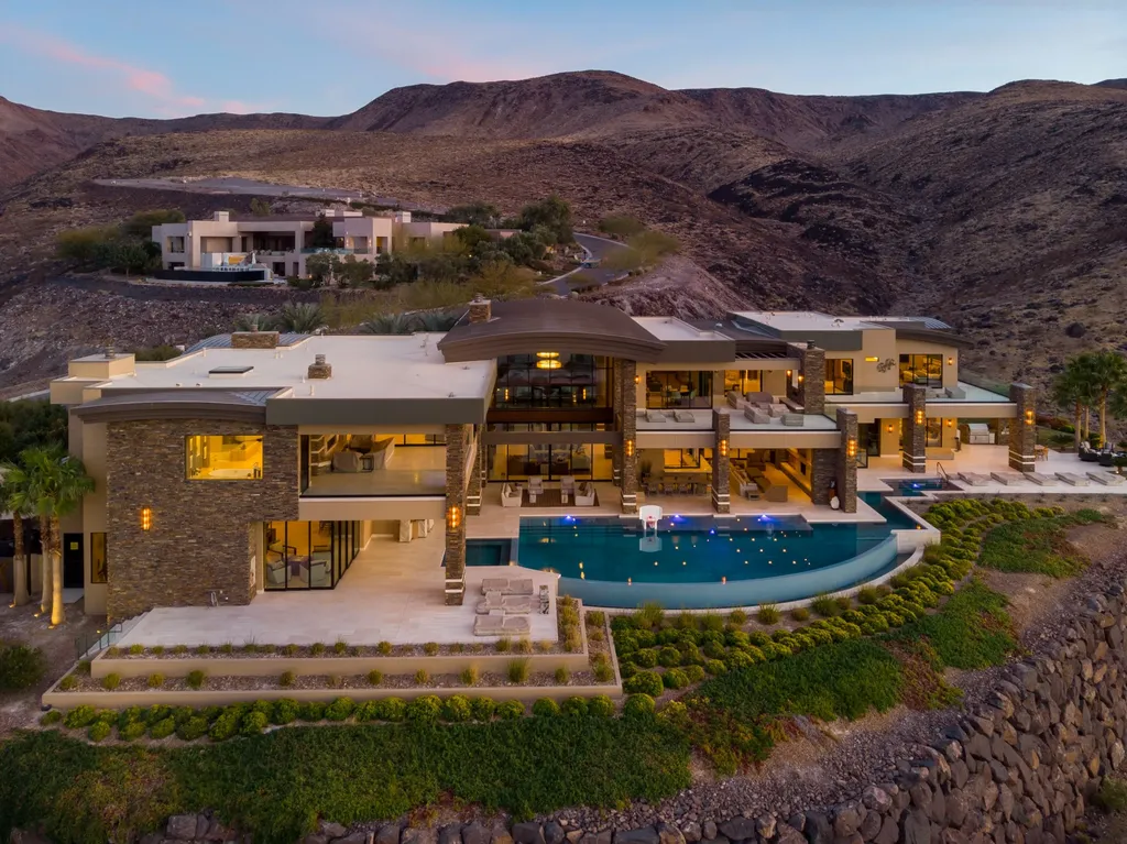 This extraordinary estate located at 761 Dragon Ridge Drive in Henderson, NV offers an unparalleled level of luxury and sophistication. Situated within the exclusive 9-lot enclave in Macdonald Highlands, this magnificent residence is nestled on a sprawling 1.23-acre lot, providing ample space and privacy.