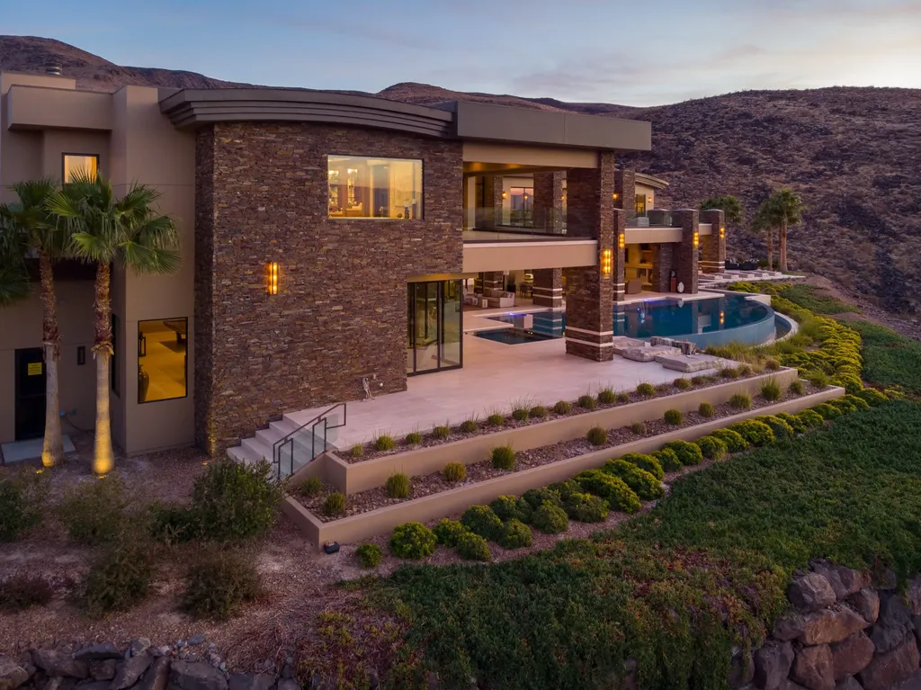 This extraordinary estate located at 761 Dragon Ridge Drive in Henderson, NV offers an unparalleled level of luxury and sophistication. Situated within the exclusive 9-lot enclave in Macdonald Highlands, this magnificent residence is nestled on a sprawling 1.23-acre lot, providing ample space and privacy.