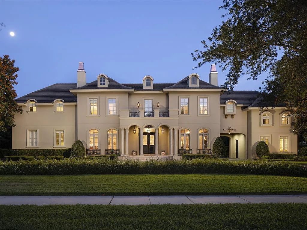 Experience a magnificent New Orleans-inspired custom estate in guard-gated Lake Butler Sound at 11114 Bridge House Road, Windermere, Florida. This 5-bed, 7-bath French Chateau on 0.94 acres boasts a 7,138 sq ft living space, impeccable grounds, and stunning features such as de Gournay hand-painted wallpaper, a gourmet kitchen, and a vaulted pecky cypress ceiling.