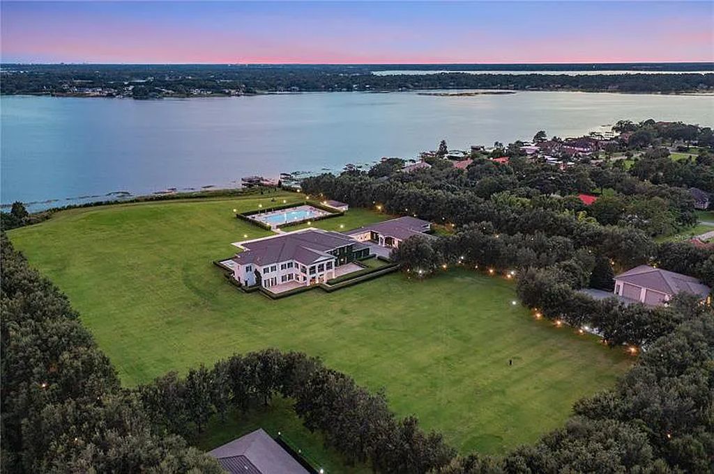 Experience luxury at 9508 Windy Ridge Road, Windermere, Florida - an exquisite lakefront estate on 18 acres with stunning views of Lake Down. This gated compound offers 7 bedrooms, 16 bathrooms, and over 29,000 square feet of living space.