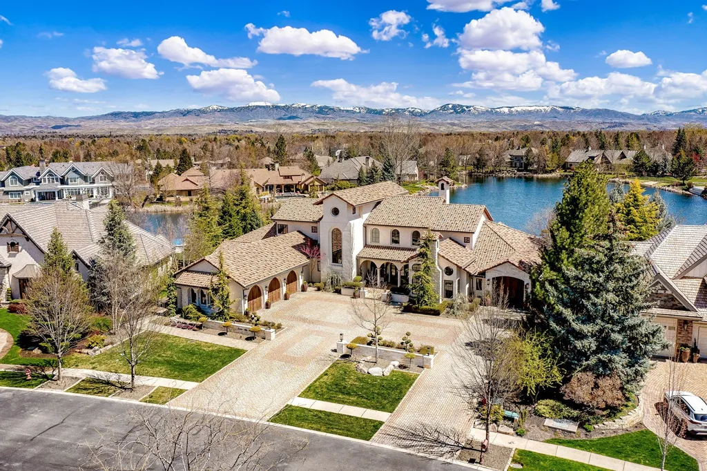 1454 S Heron Pointe Lane Home in Eagle, Idaho. Discover the epitome of luxury and quality in this exceptional Santa Barbara style custom home. Built by renowned Northern Construction and designed by acclaimed architect Trey Hoff, this 1.5-acre waterfront property boasts stunning Spanish Colonial architecture. Step into a world of elegance with an infinity pool, spa, and covered outdoor living area featuring custom sound, heaters, televisions, fireplace, and lighting.