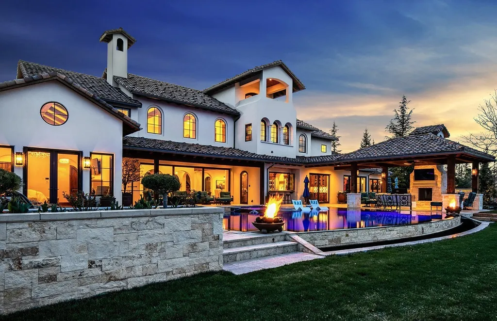 1454 S Heron Pointe Lane Home in Eagle, Idaho. Discover the epitome of luxury and quality in this exceptional Santa Barbara style custom home. Built by renowned Northern Construction and designed by acclaimed architect Trey Hoff, this 1.5-acre waterfront property boasts stunning Spanish Colonial architecture. Step into a world of elegance with an infinity pool, spa, and covered outdoor living area featuring custom sound, heaters, televisions, fireplace, and lighting.