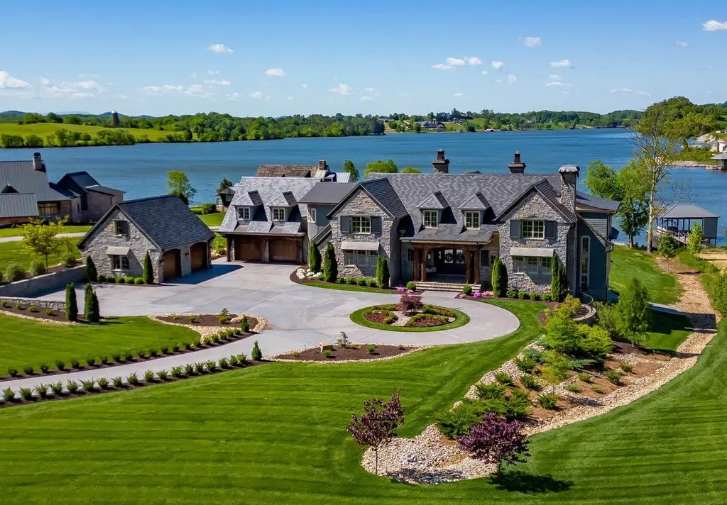 10416 Leonidas Meadow Way Home in Knoxville, Tennessee. Experience the epitome of lakeside luxury in the prestigious West Knoxville enclave of Arcadia. Nestled within this exclusive community, this opulent estate stretches across more than 2.5 acres of prime lakefront property, offering an astonishing 13,000 square feet of meticulously crafted living space. With custom millwork and intricate stonework adorning every corner, this slate and stone residence was artfully constructed with lavishness in mind.