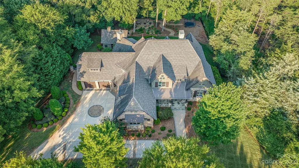 13105 Ninebark Trail Home in Charlotte, North Carolina. Discover the epitome of luxury living in this 5-bedroom, 5.5-bathroom estate nestled on a sprawling 3.3-acre lot in the sought-after community of The Sanctuary. Exuding elegance with brick and stone exteriors, the property boasts a custom pool and captivating outdoor oasis with lush landscaping.
