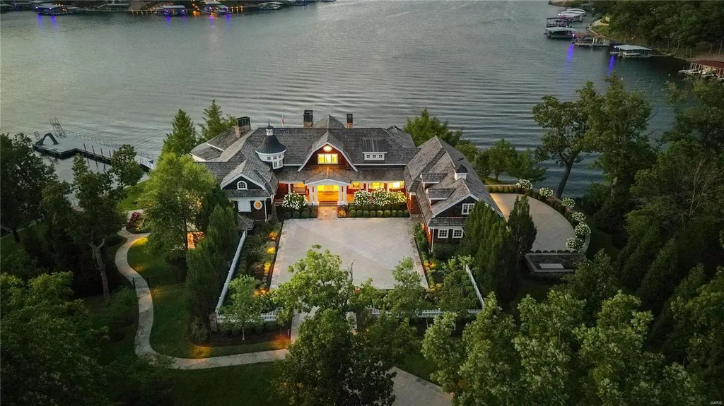 282 Timber Ridge Lane Home in Lake Ozark, Missouri. "Nantucket Point" is the ultimate Crown Jewel of Lake of The Ozarks, offering 1.24 acres of unparalleled beauty with 500' of shoreline, deep water, and breathtaking views. This Nantucket-inspired 6,800 sqft estate exudes laid-back luxury and coastal design, featuring 6 ensuite bedrooms, 2 gourmet kitchens, a gym, game room, and more. 