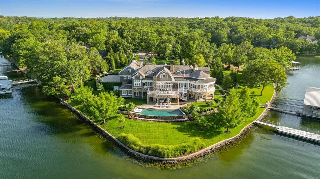 282 Timber Ridge Lane Home in Lake Ozark, Missouri. "Nantucket Point" is the ultimate Crown Jewel of Lake of The Ozarks, offering 1.24 acres of unparalleled beauty with 500' of shoreline, deep water, and breathtaking views. This Nantucket-inspired 6,800 sqft estate exudes laid-back luxury and coastal design, featuring 6 ensuite bedrooms, 2 gourmet kitchens, a gym, game room, and more. 
