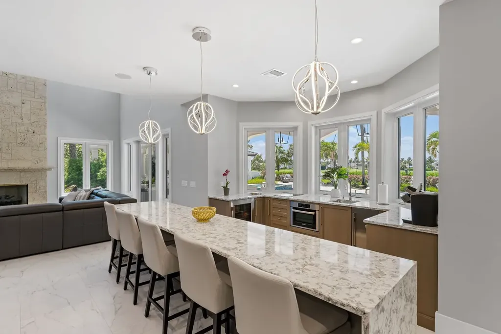 3057 SE Dune Drive Home in Stuart, Florida. Discover this artfully reimagined and fully renovated home boasting panoramic views of a Jack Nicklaus golf course, the lake, and the ocean. Flooded with natural light through 166 windows, the neutral palette accentuates exquisite finishes and architectural details. 