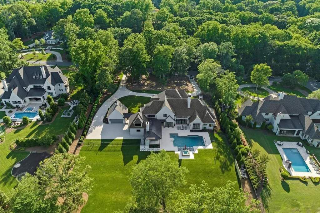 519 Brackenbury Lane Home in Charlotte, North Carolina. Discover a truly unique modern Kingswood Home built in 2019, an exquisite and meticulously designed residence that showcases the epitome of luxury living. With 7,491 square feet spread over 2 acres, this home boasts a custom curved stairwell by Artisan, a stunning glass refrigerated wine display room, and Walker Zanger light gray stone tile throughout the main and upper levels. 