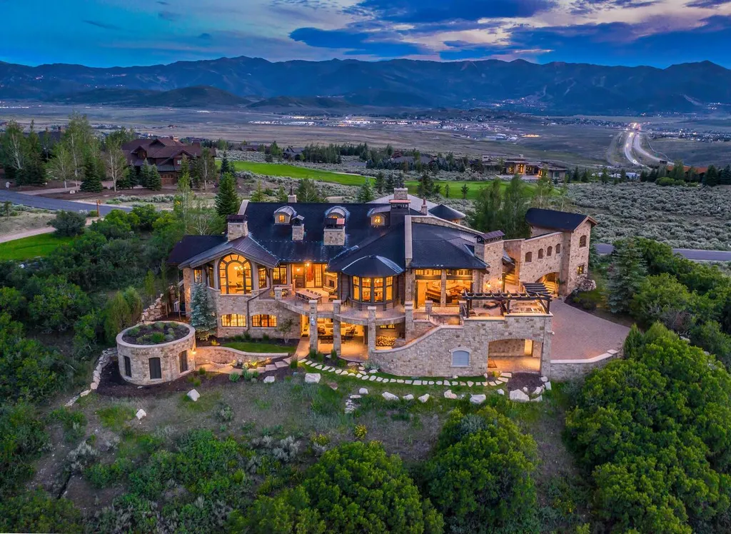 7971 N West Hills Trial Home in Park City, Utah. Discover Villa del Alce, an exceptional European estate perched on a panoramic view lot in Park City's esteemed Promontory Ranch Club. This meticulously designed home seamlessly blends family comfort, work, and play, boasting an ideal layout that embraces year-round indoor-outdoor living. Crafted with unparalleled attention to detail, this residence showcases handcrafted Biblical stone, reclaimed 200-year-old barn beams, and intricately carved wood elements throughout.