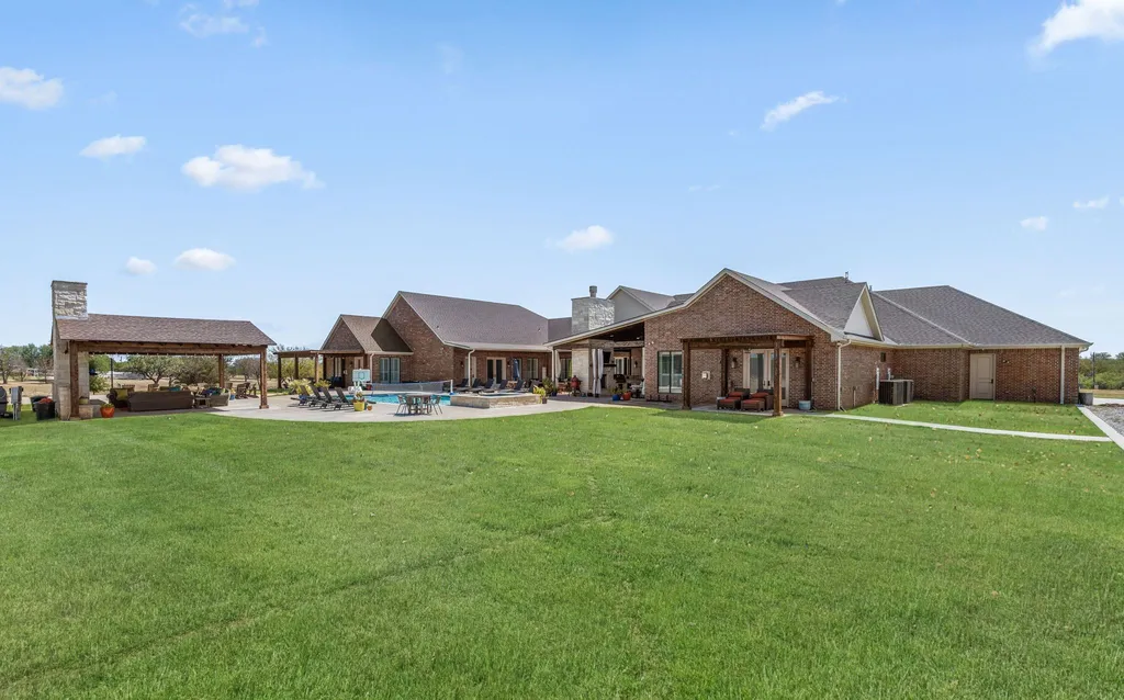 1134 Kinta Trial Home in Wichita Falls, Texas. Discover this unique 10-acre property in Clay County, featuring a stunning 6-bedroom home with 6.5 bathrooms, 6 fireplaces, a heated pool, outdoor kitchen, and even a catfish pond for fishing.